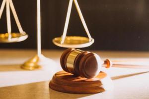 Business and lawyers discussing contract papers with brass scale on desk in office. Law, legal services, advice, justice and law concept photo