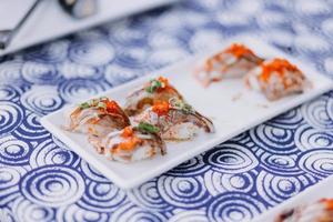 Man eating sushi set with chopsticks on restaurant photo