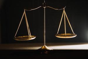 Business and lawyers discussing contract papers with brass scale on desk in office. Law, legal services, advice, justice and law concept photo