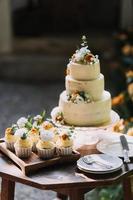 Gourmet cupcakes with white buttercream frosting and sprinkles on wooden background photo