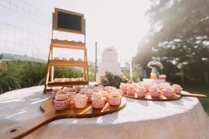 Gourmet cupcakes with white buttercream frosting and sprinkles on wooden background photo