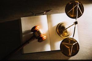 Business and lawyers discussing contract papers with brass scale on desk in office. Law, legal services, advice, justice and law concept photo