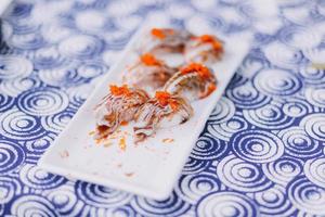 Man eating sushi set with chopsticks on restaurant photo