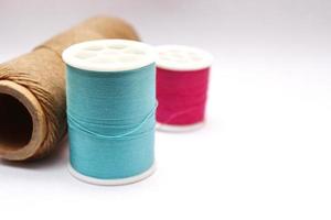 Green, red, brown spools placed on a white background. photo