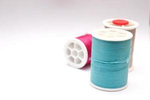 Green, red, colored thread spools placed on a white background. photo