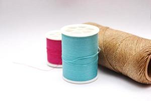 Green, red, brown spools placed on a white background. photo