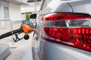 Image of refueling with gasoline in a car's gas tank at a gas station. Oil service industry, oil prices and oil crisis concept. photo