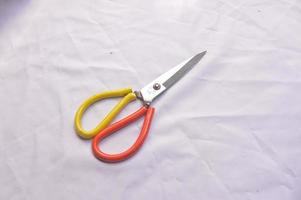 large yellow and orange scissors on a white background photo