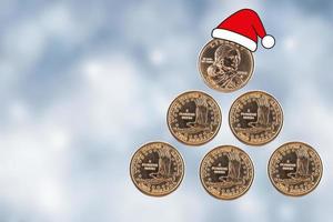 Christmas tree. Coins of one US dollar are stacked in the form of a pyramid and a Santa Claus hat on a blurred New Year's background. photo