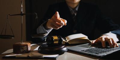 Business and lawyers discussing contract papers with brass scale on desk in office. Law, legal services, advice, justice and law concept picture with film grain effect photo