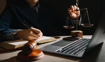 Business and lawyers discussing contract papers with brass scale on desk in office. Law, legal services, advice, justice and law concept picture with film grain effect photo