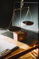 law books and scales of justice on desk in library of law firm. jurisprudence legal education concept. photo