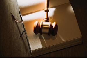 law books and scales of justice on desk in library of law firm. jurisprudence legal education concept. photo