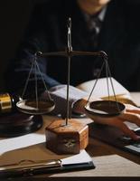 law books and scales of justice on desk in library of law firm. jurisprudence legal education concept. photo