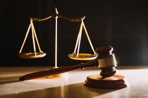 law books and scales of justice on desk in library of law firm. jurisprudence legal education concept. photo