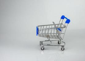 Shopping cart on white background with light and shadow. schopping concept. photo