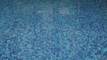 Rain droplets drops falling onto the surface of a swimming pool, Close up rain drop splash into the pool. Rainy mood weather forecast nature background video