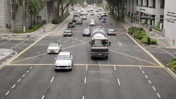 vista del paisaje con la calle y el tráfico de camiones en la calle asfaltada en la intersección entre el centro de la ciudad de singapur con el fondo de un edificio moderno en singapur video