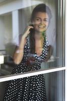 Gorgeous woman wearing beautiful dress with a polka dot pattern looking through the window photo