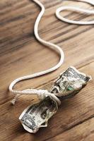 White rope tangled around a crumpled one dollar bill. photo