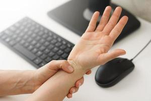 Female hands with a pain in the wrist because of carpal tunnel syndrome photo