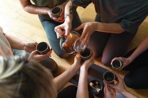 Woman pouring tea to her friends during tea ceremony. photo