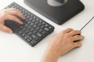 Female hands using computer pc on workplace in office photo