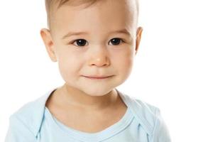 primer plano de la cara sonriente del niño pequeño en mameluco. foto