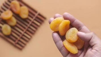 Dried apricots in hand and on table video