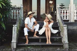 Young lovely couple sitting on the stairs of the porch photo