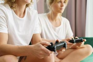 Two girls playing video game console in living room photo