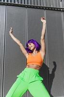 bailarina despreocupada con ropa deportiva colorida divirtiéndose en la calle durante el día soleado de verano