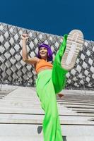 Active woman wearing colorful sportswear performing on the street during summer day photo