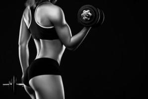 mujer joven fitness durante el entrenamiento con pesas foto