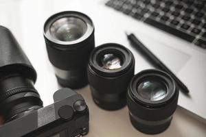 Workplace with a modern equipment for photography. Mirrorless camera and prime lenses. photo