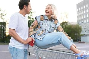 Young couple with a shopping trolley on supermarket parking photo