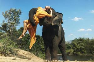 Mighty elephant lifting up the young and beautiful woman photo