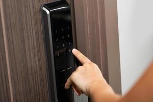 Hand and digital smart code lock into the modern apartment photo