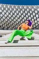 mujer activa con ropa deportiva colorida actuando en la calle durante el día de verano foto