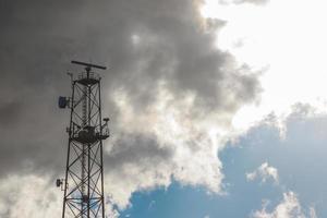 Upward shot of metallic telecommunication tower with sky background. photo