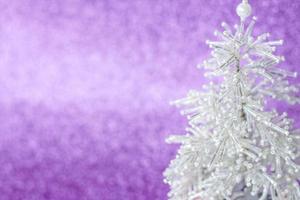 Snow-white, beautiful and very shiny Christmas tree made of beads. White Christmas tree on purple background. New year greetings, postcards, calendar. photo