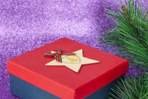 Christmas gift. Gift under the Christmas tree on a purple background. photo