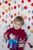 retrato de un chico lindo con un regalo en sus manos. emociones de los niños. Navidad y Año Nuevo. foto
