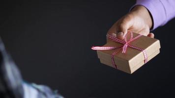 Giving a gift box wrapped in red ribbon video