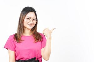 presentando y señalando el producto lateral usando el pulgar de una hermosa mujer asiática aislada en blanco foto