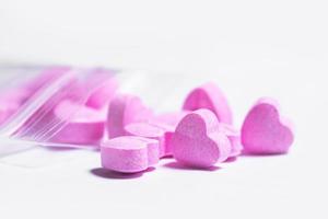 Ziplock bag and pink heart shaped pills. photo