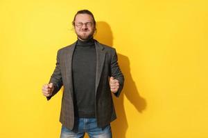 Man making silly face against yellow background photo