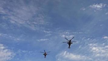 Helicópteros de ataque volando en el cielo en demostración de aviación. video