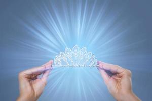 Diadem in female hands with a light rays photo