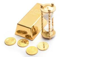 Time to invest. Gold bullion, hourglass and bitcoins. photo